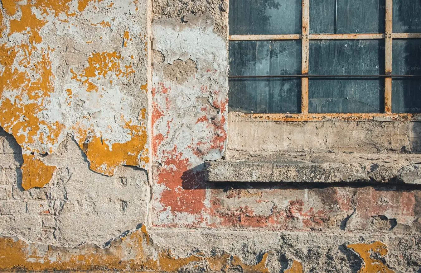 Older window set into the weathered exterior wall of a condo building